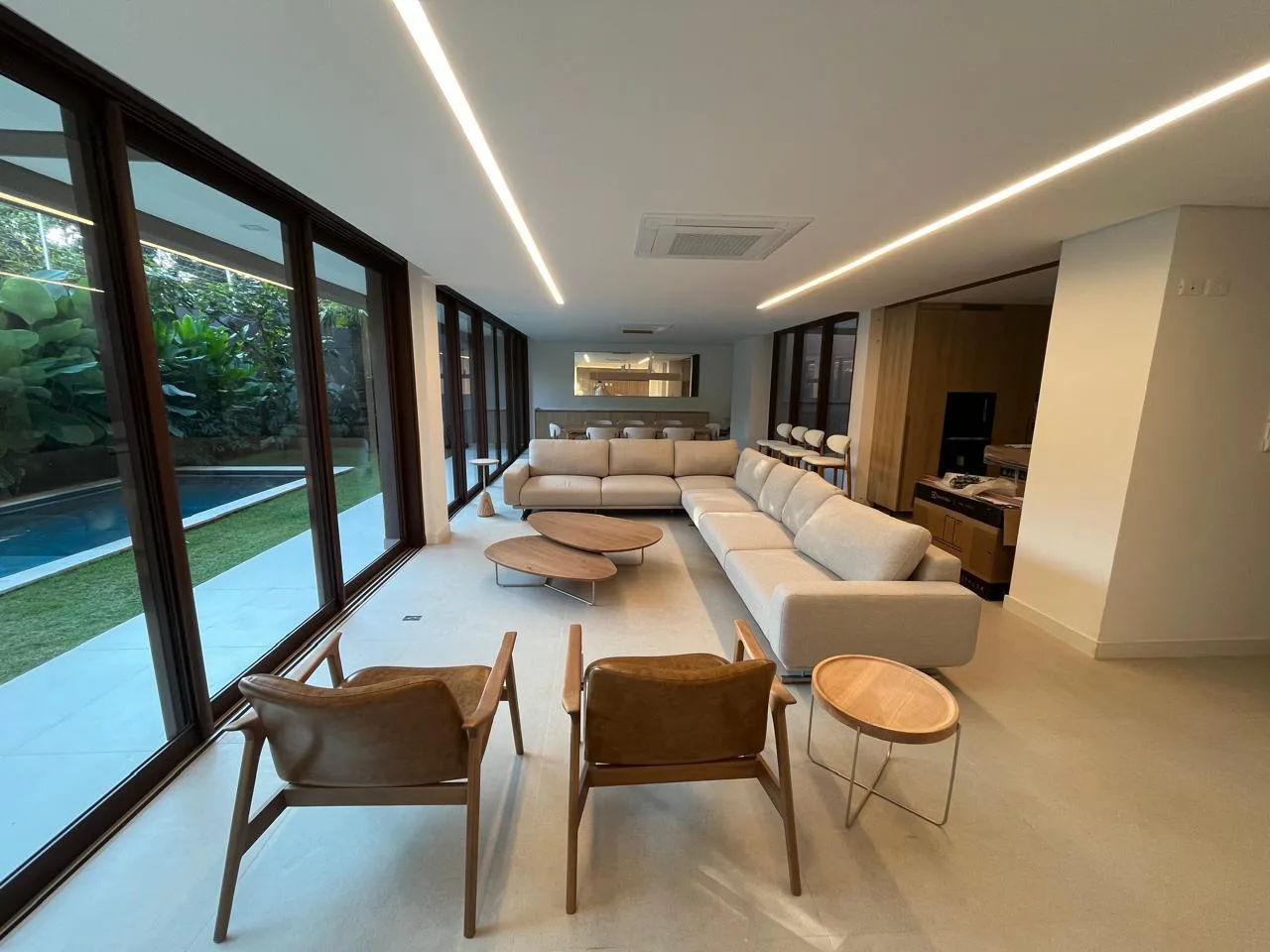 Living room mobiliado com sofá e vista para piscina — Casa Flora Badra